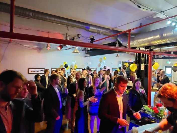Crowd mingling beneath industrial ceiling and balloon décor at a lively SkyLofts Gallery party.