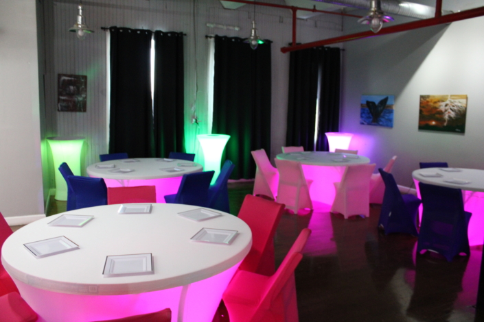Glow-lit cocktail tables and neon chair covers transforming SkyLofts Gallery into a vibrant nightlife event space.